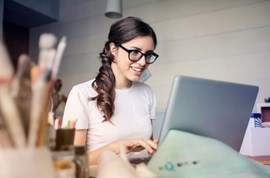 Woman looking and smiling at her laptop