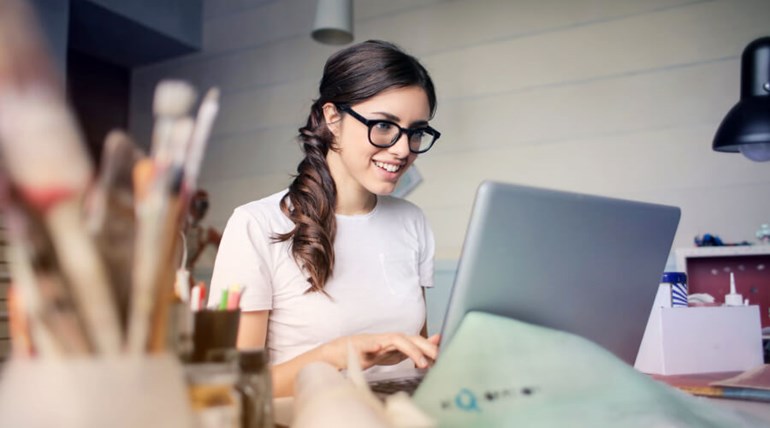 Woman looking and smiling at her laptop