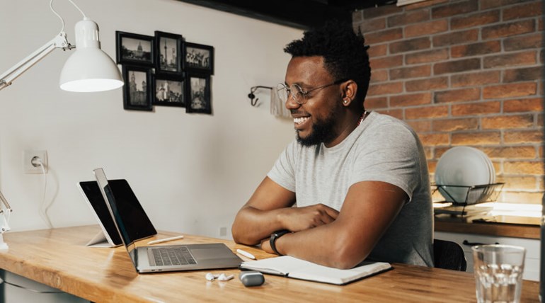 Smiling man using laptop