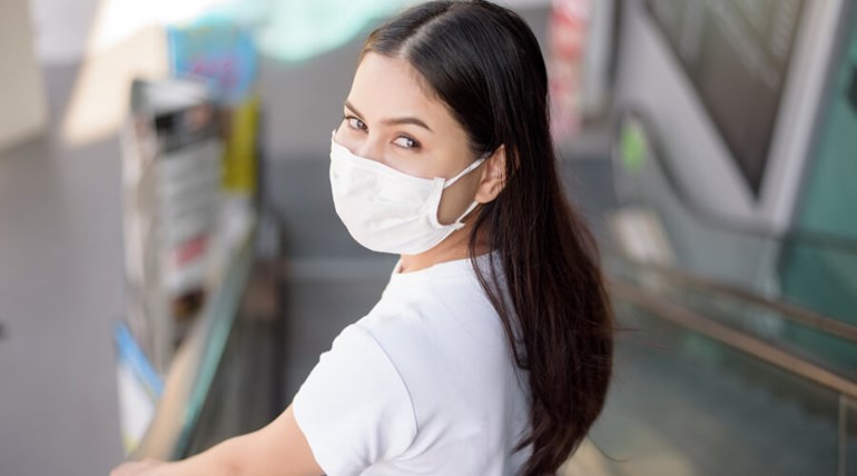 Woman wearing mask on an escalator