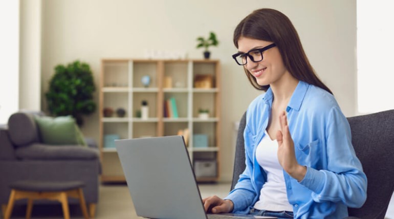 Student waving at her laptop