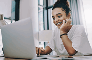 Woman looking and smiling at her laptop