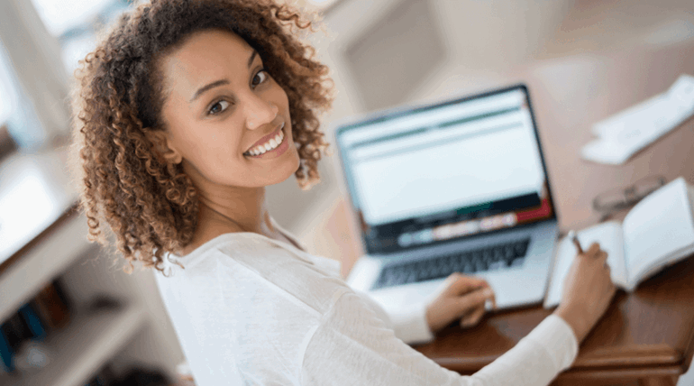 Woman facing the camera away from her laptop