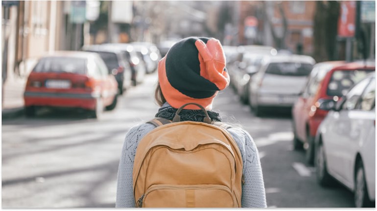 A woman facing a street full of cars