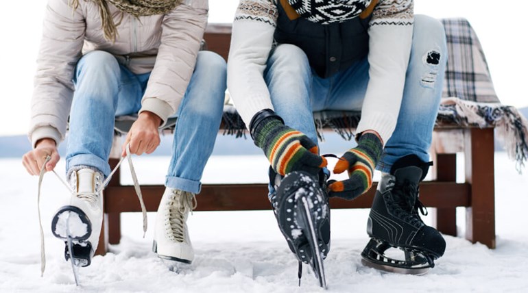 Two people tying their ice skates