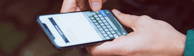 Image of hands typing on a phone