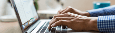 Image of hands typing on a laptop