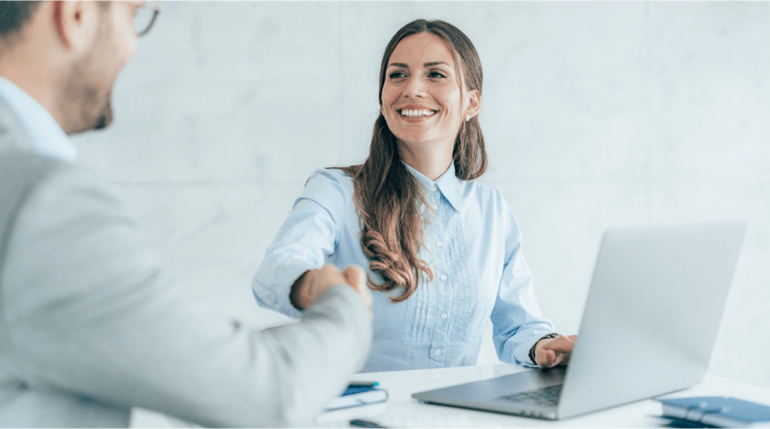 Smiling business people shaking hands sitting in the office