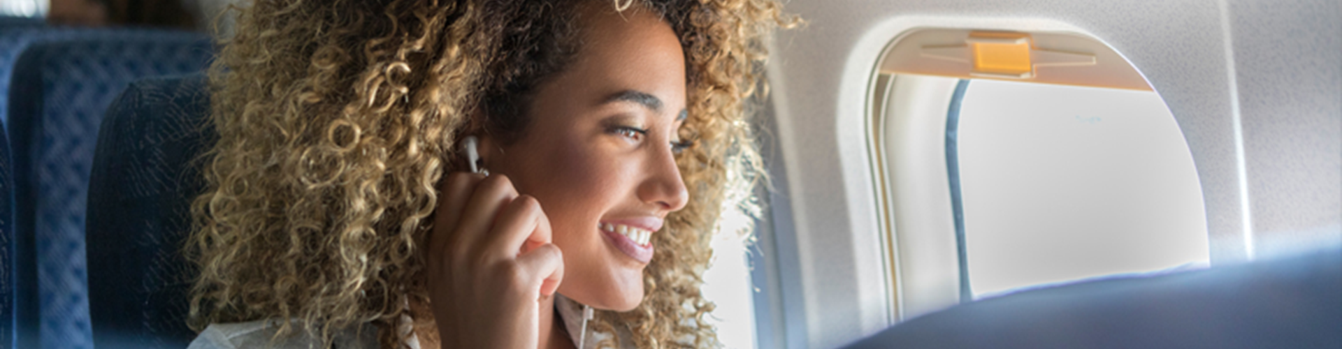 A woman listening to music with earphones on the plane