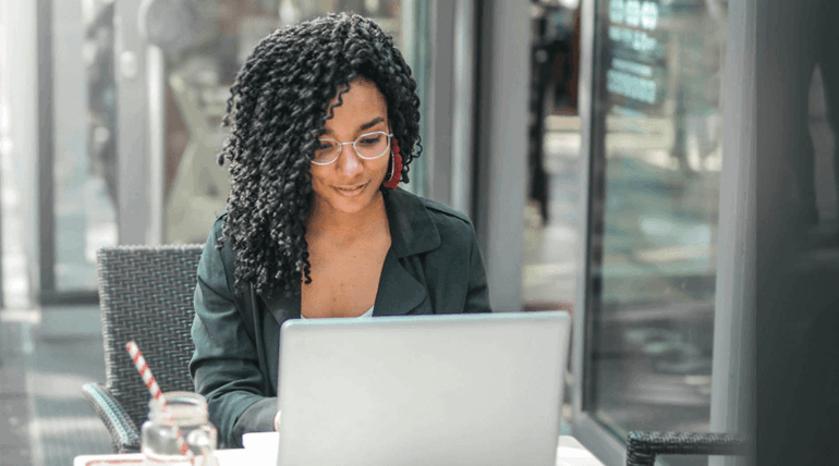 Woman looking and smiling at her laptop