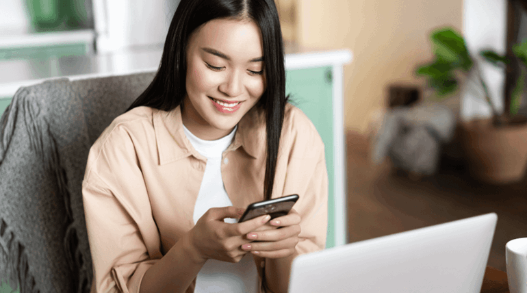 Young student smiling and looking at mobile