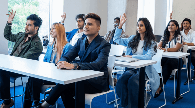 A large group of college students participates in class.