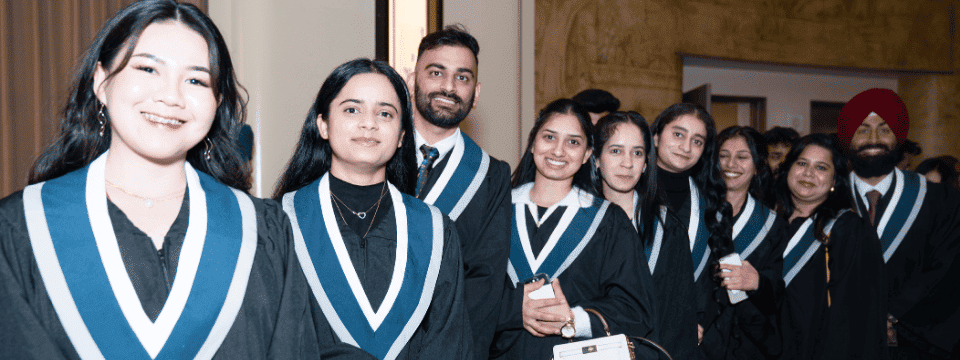 Graduates smiling together at an indoor