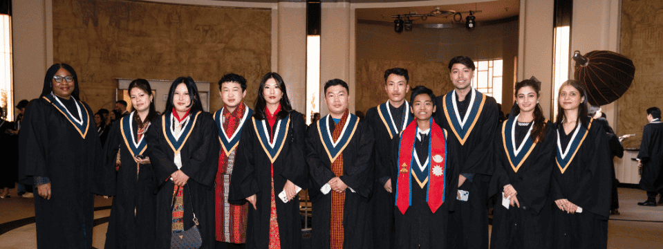 Group of graduates posing together in a hall
